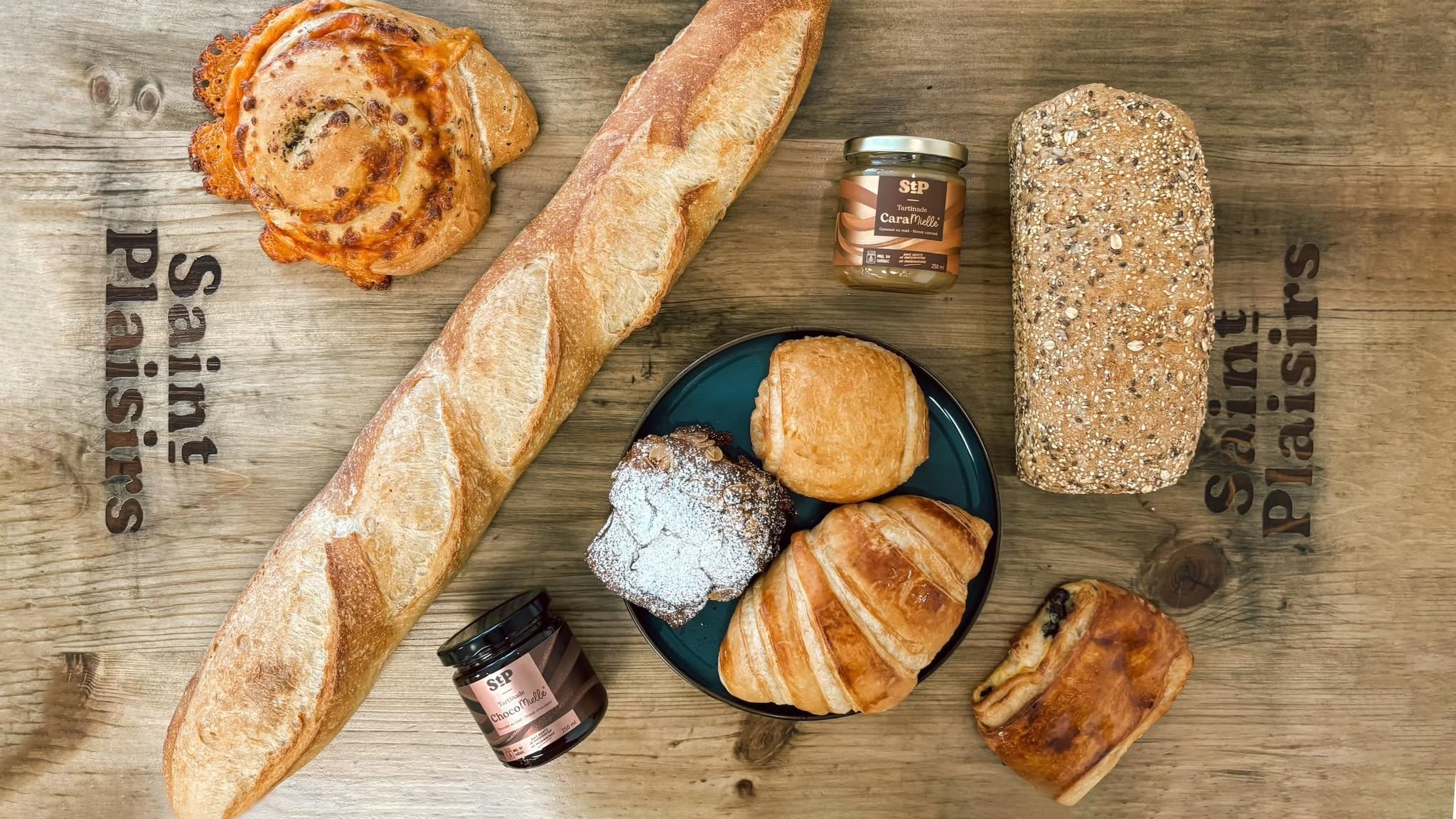 Pains artisanaux frais, croissants, pâtisseries et café sur une table en bois rustique avec lumière naturelle du matin